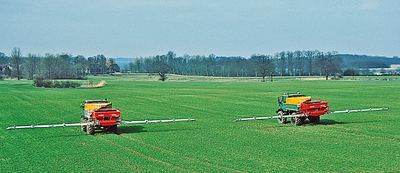 Zwei 18-m-TURBO-Streuer hinter Unimogs auf einem Großbetrieb in Schleswig-Holstein.